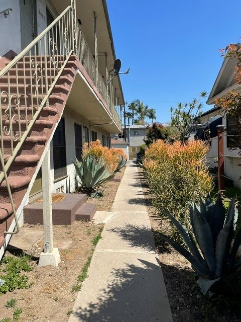 A concrete pathway leads to a staircase outside a building.
